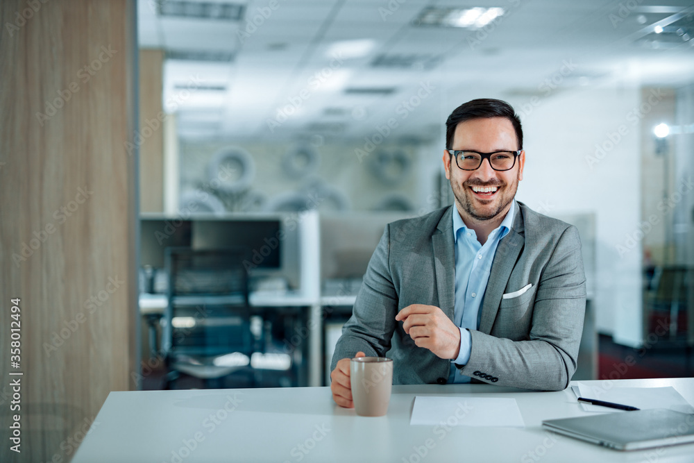 Portrait of a successful corporate manager at workplace, looking at camera