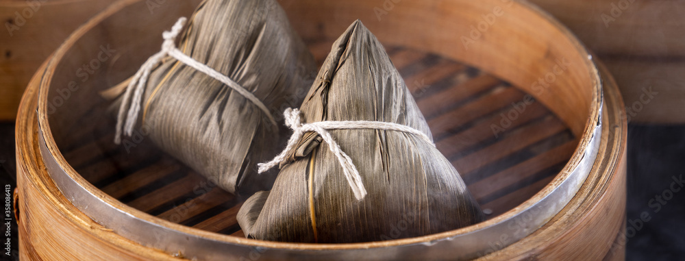 Rice dumpling, zongzi - Chinese rice dumpling zongzi on black brick background slate table, concept 