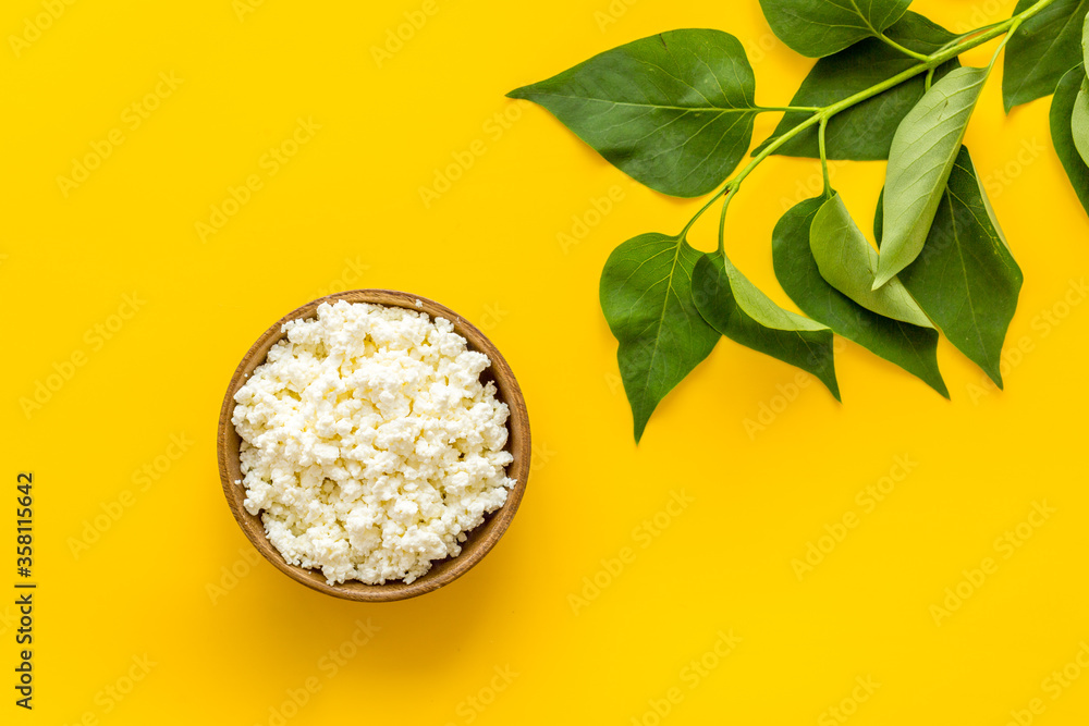 Breakfast still life. Cottage cheese in bowl, green branch top view