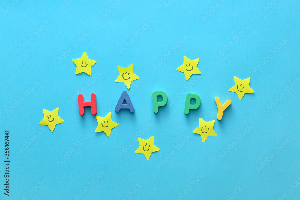 Paper stars with drawn faces and word HAPPY on color background