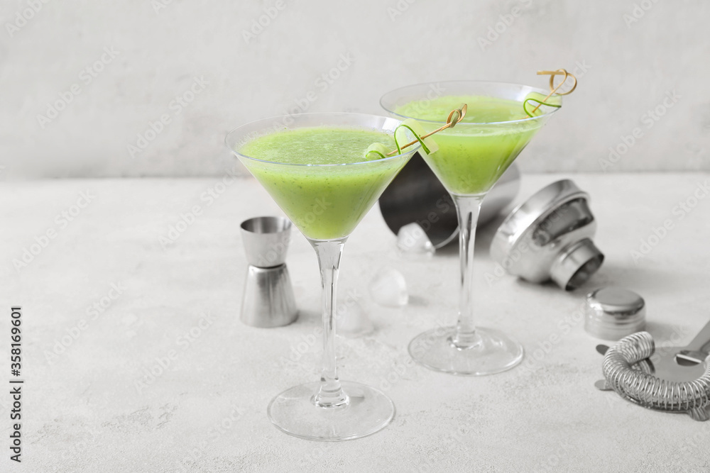 Glasses of tasty cucumber martini on white background