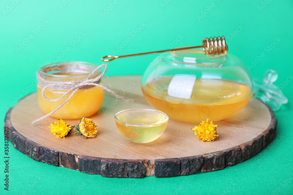 Tasty dandelion honey on color background