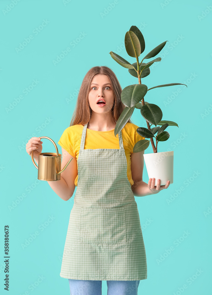 带着喷壶和彩色背景的室内植物，让一位年轻女士大吃一惊