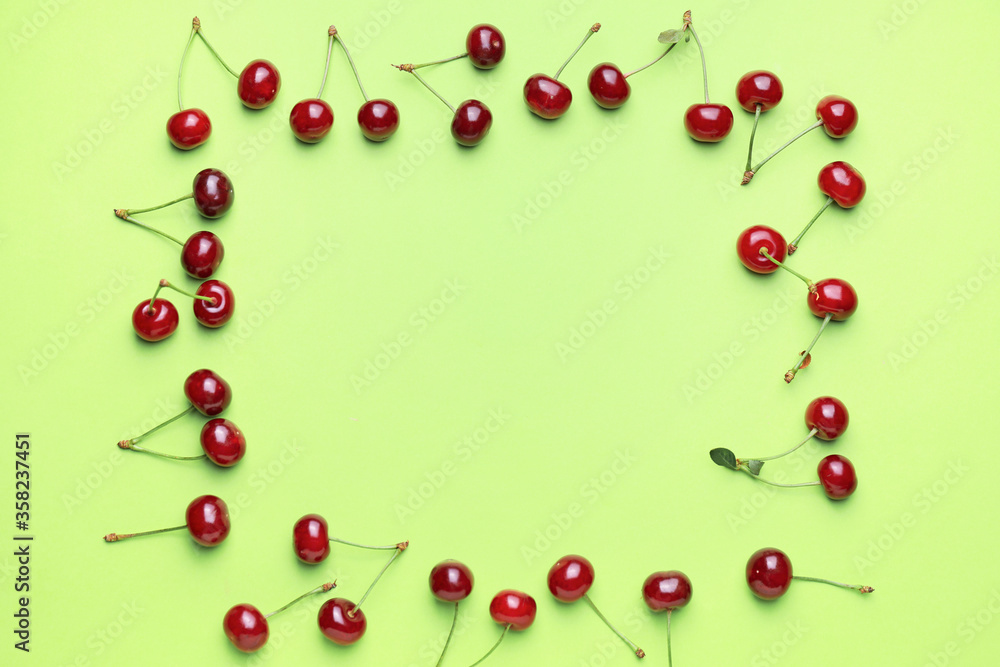 Frame made of sweet cherry on color background