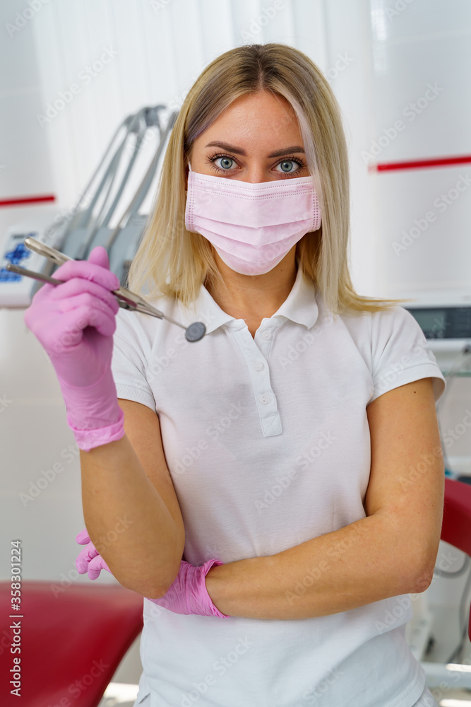 Female dentist is working in modern stomatology clinic. Stomatological instruments in woman`s hands.