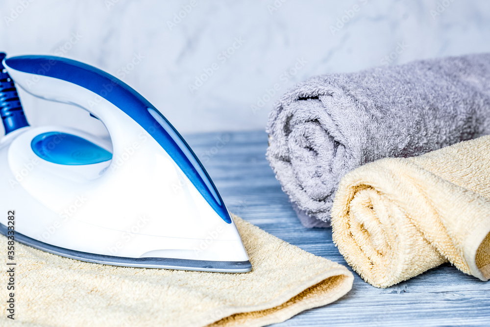 Launry set with towels and iron on gray background