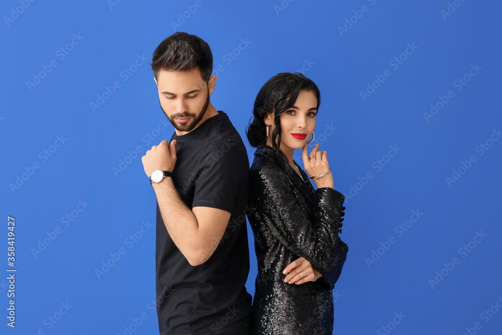 Young couple wearing stylish accessories on color background