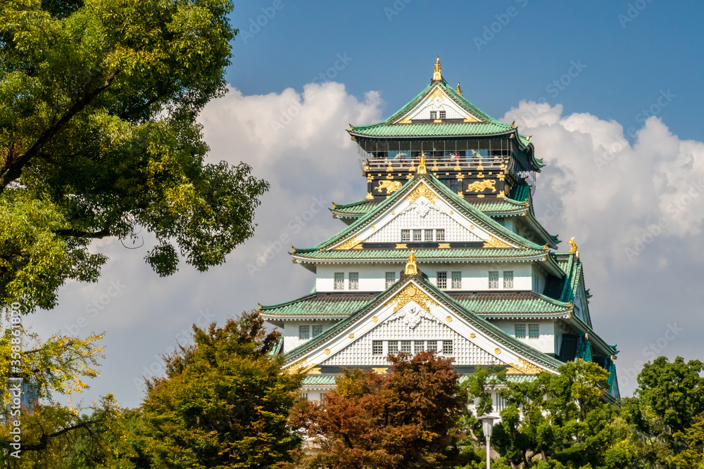 Majestic Osaka Castle view with green roof among colorful autumn trees, Japan