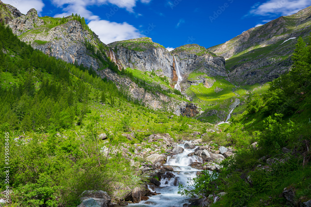 Scenic waterfall and mountain river on the italian Alps. Tourism destination hiking outdoors activit