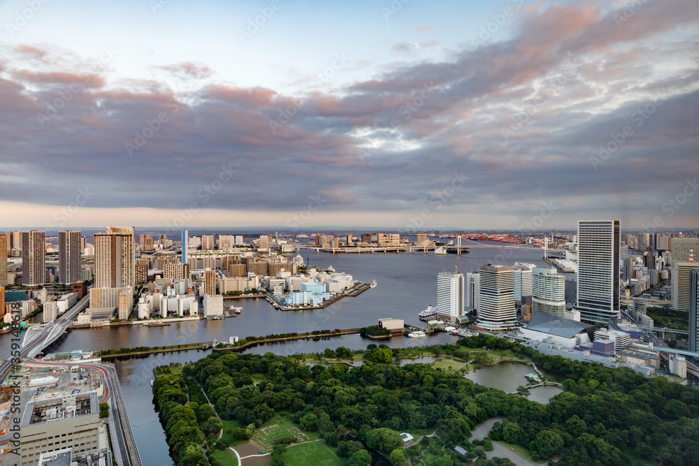 東京の水辺に建つビル群と夕焼けの空