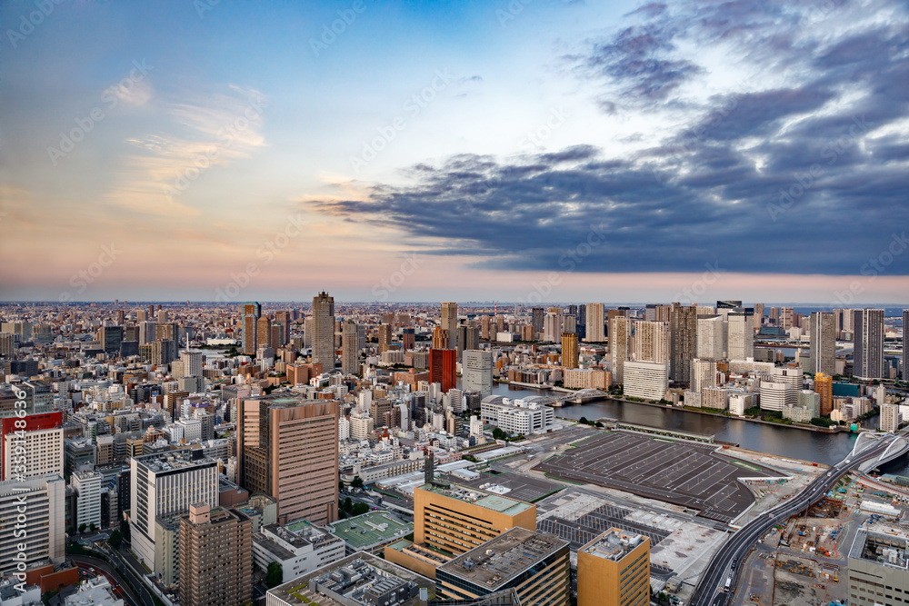 東京の水辺に建つビル群と夕焼けの空