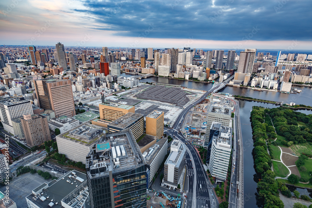 東京の水辺に建つビル群と夕焼けの空