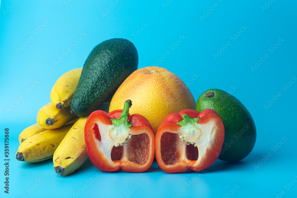 Summer fruits and vegetables on a clear blue background. Harvest, vitamins and vegetarian (vegan) co