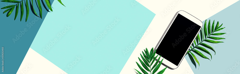 Smartphone with tropical palm leaves - flat lay