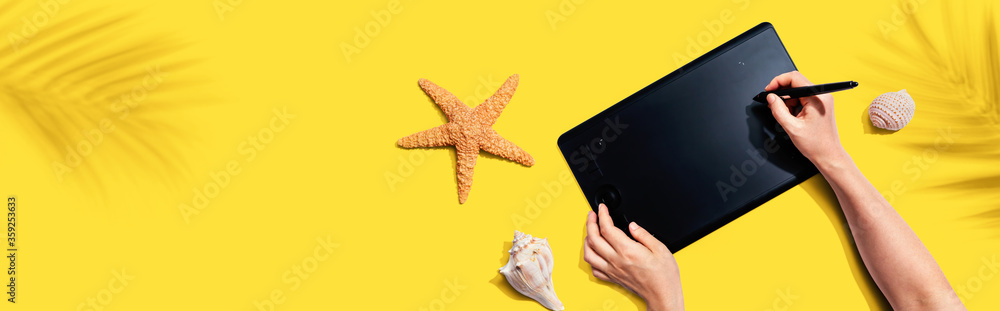 Graphic pen tablet with starfish and sea shells - flat lay