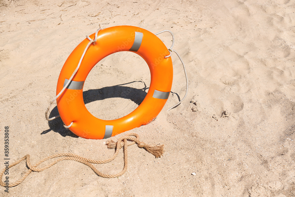 Bright lifebuoy ring on beach