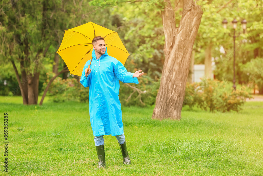 年轻人在户外打着雨伞，穿着雨衣