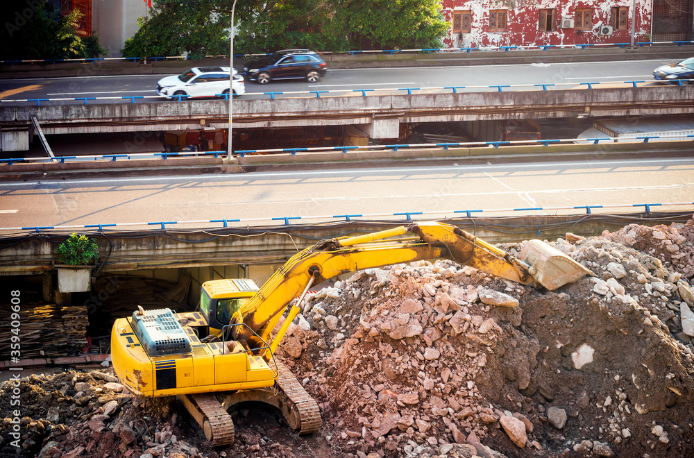 The excavator next to the highway is under construction.