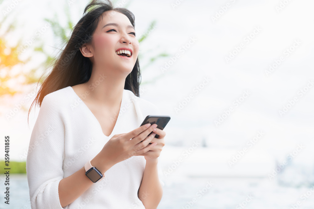 portrait of attractive asian long black hair casual dress smile hand use smartphone sit relax near s