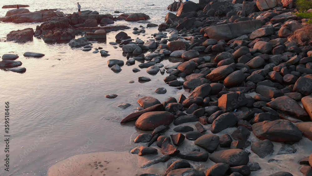 Rocky beach near Palolem beach at sunset. Goa State. India.