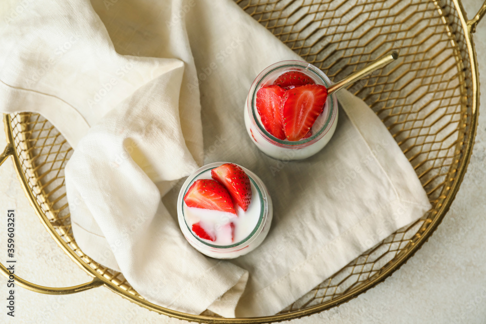 Tasty strawberry dessert in jars on tray