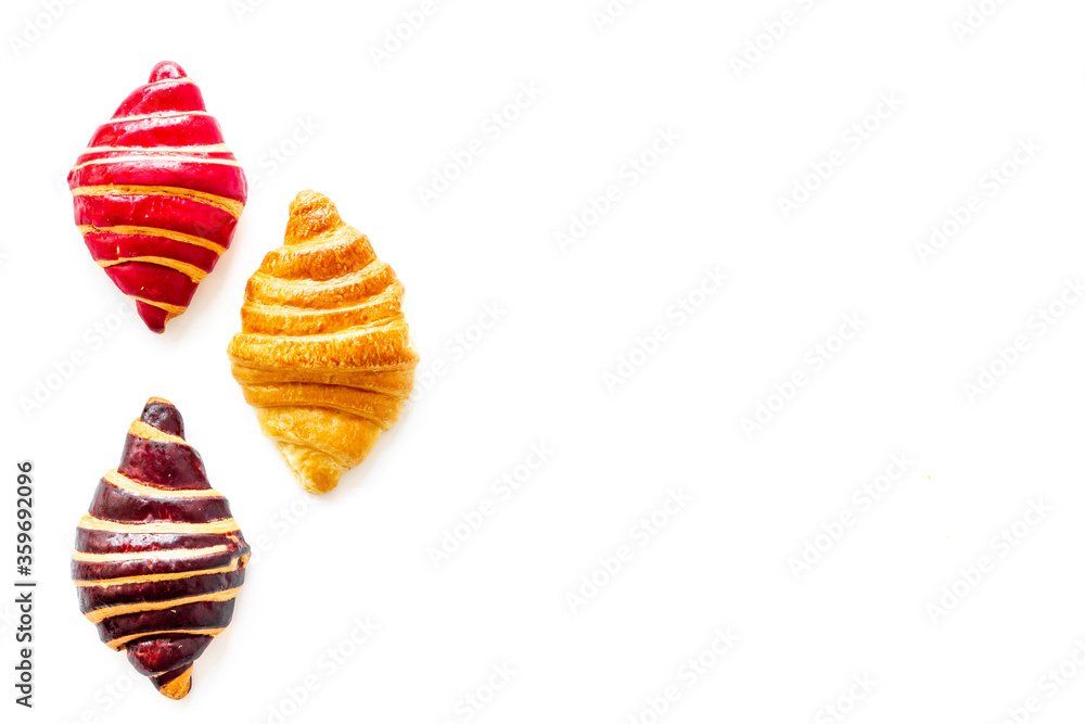 Set of croissants - chocolate, berry, classic - on white background top view