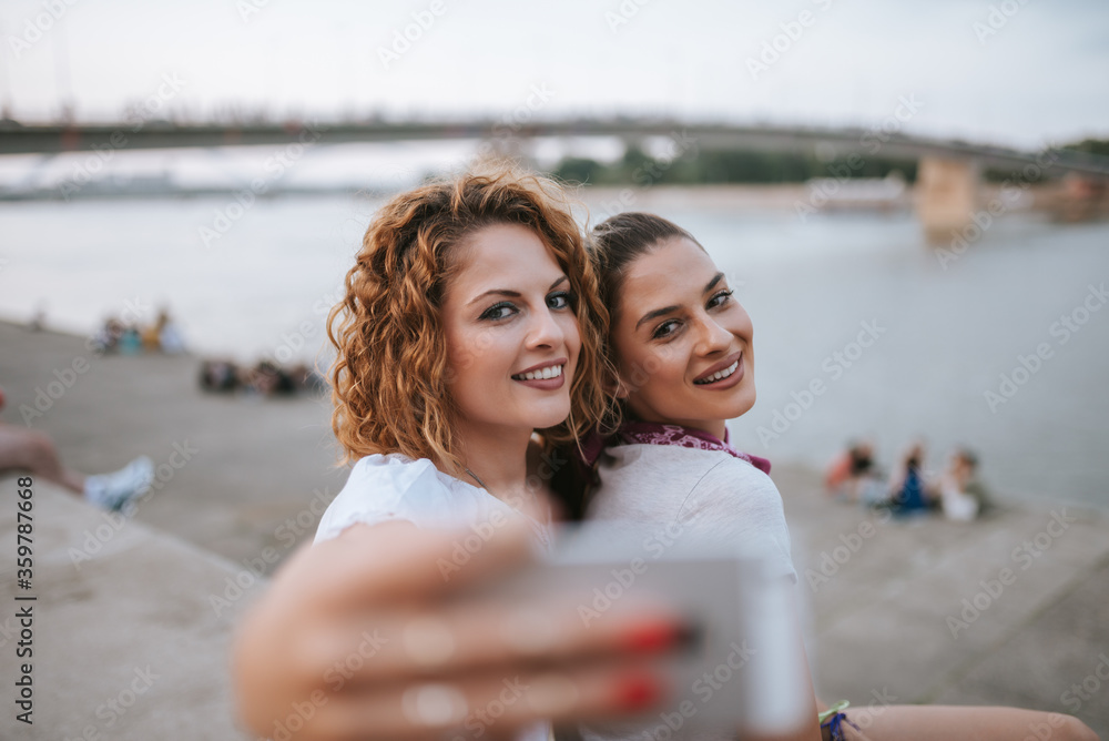 两个漂亮的年轻女人在户外自拍的特写照片。