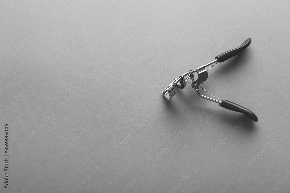 Eyelash curler on grey background