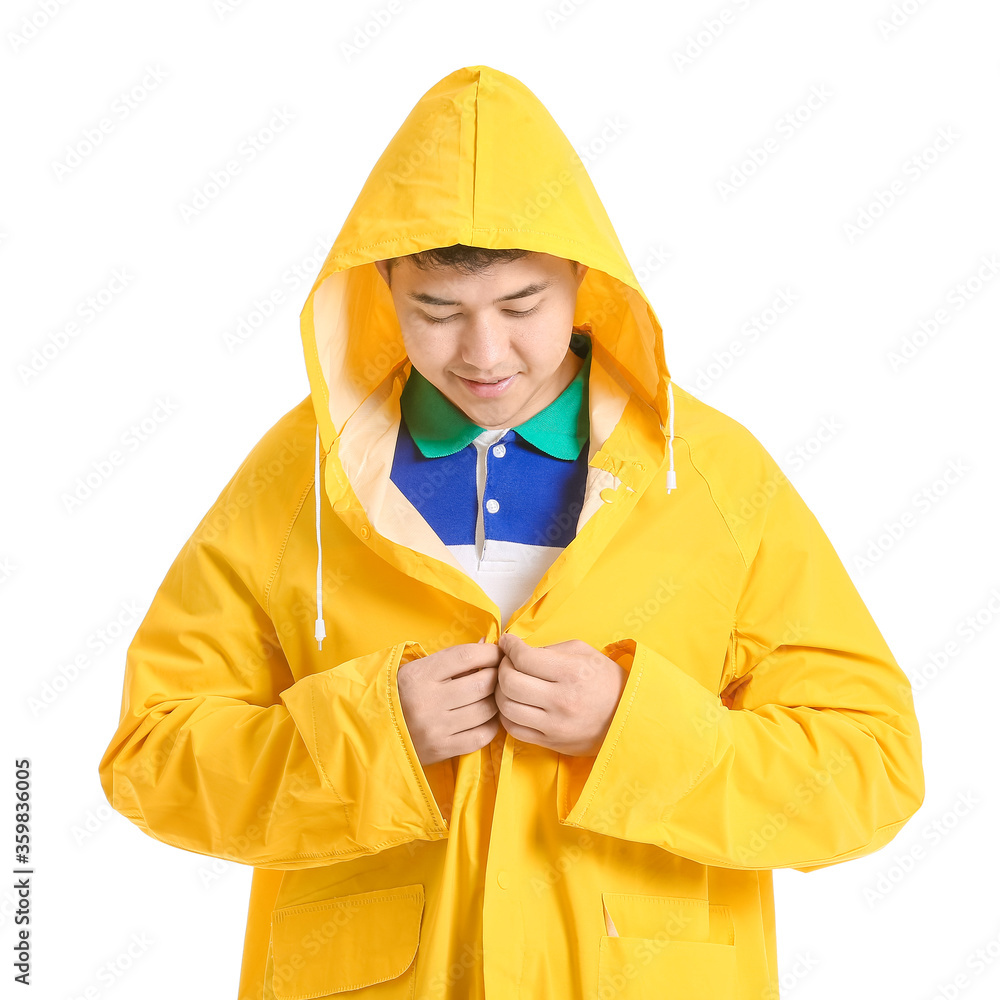 Young Asian man in raincoat on white background