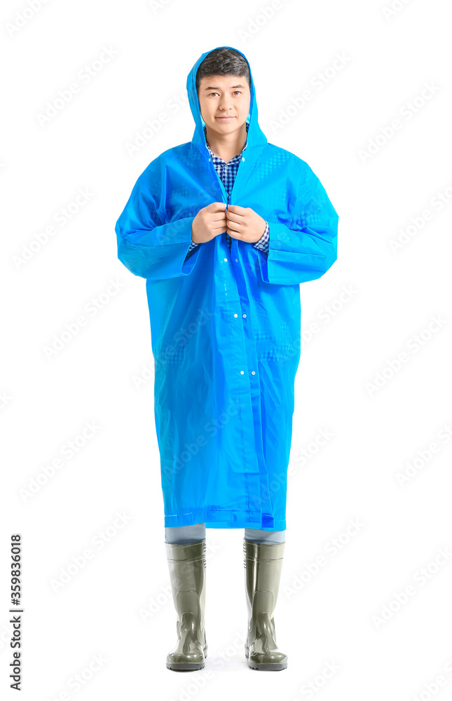 Young Asian man in raincoat on white background