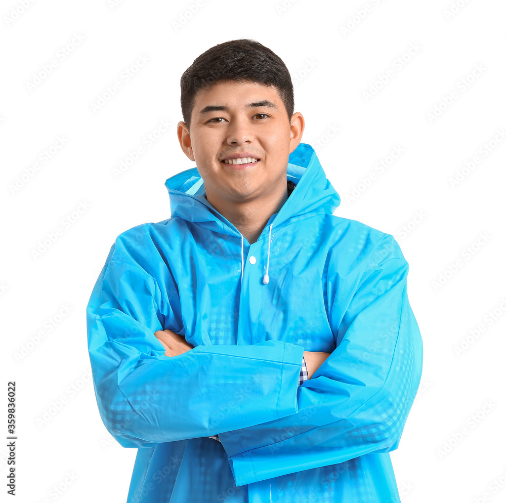 Young Asian man in raincoat on white background