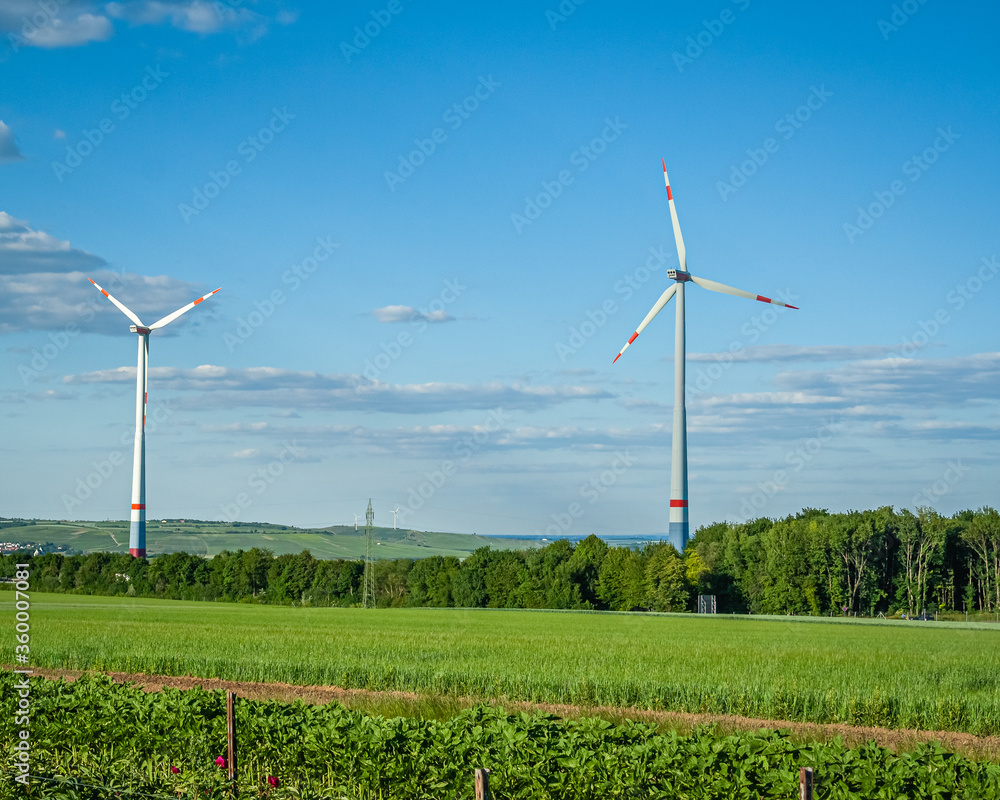 Windräder auf einem grünen Feld in der Landschaft 