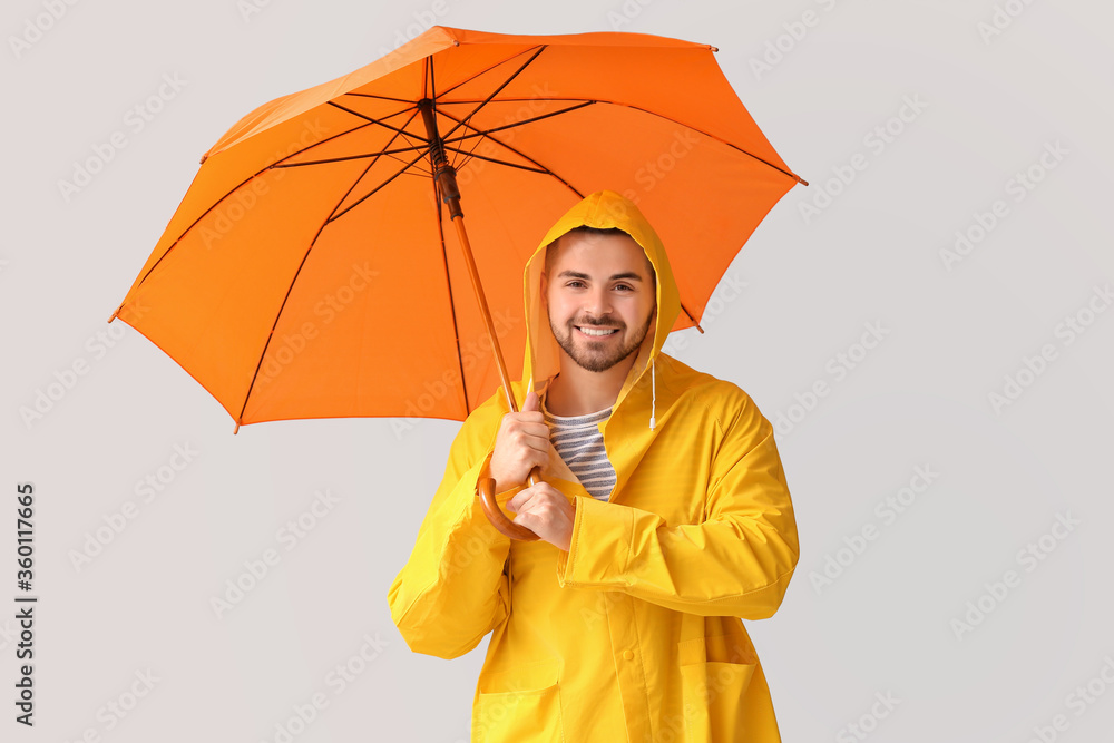 穿着雨衣、打着雨伞的年轻人