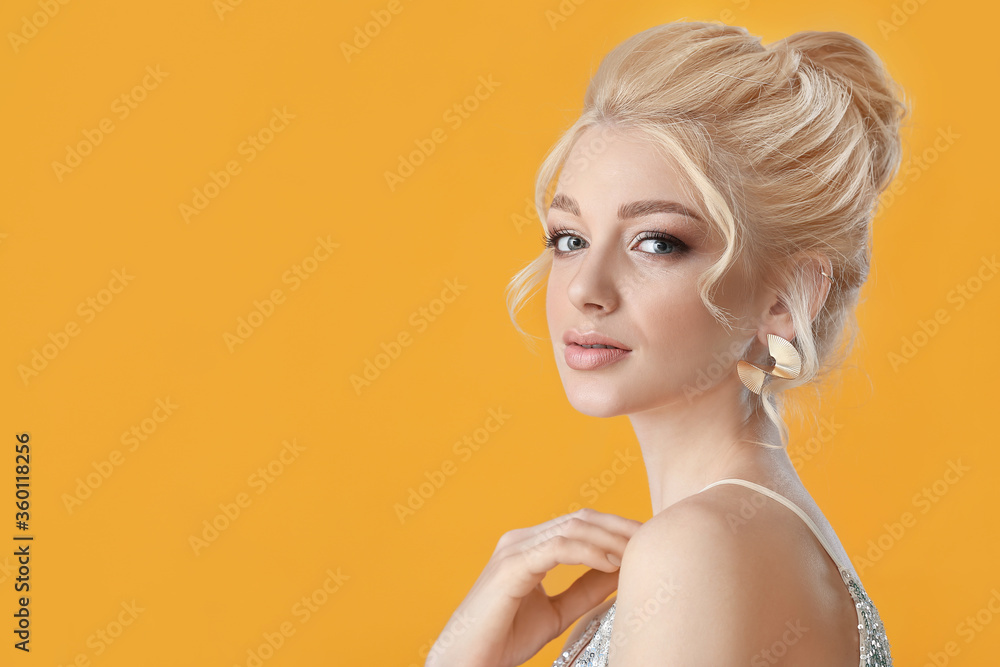 Beautiful young woman with stylish hairdo on color background