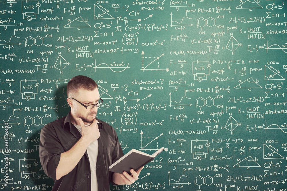 Student boy on blackboard background with formulas