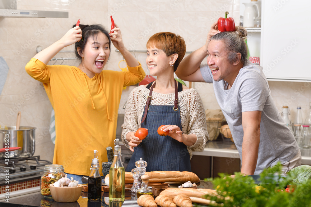 幸福的家庭，母亲、父亲和女儿在厨房做饭，一起做健康的食物，感觉很好