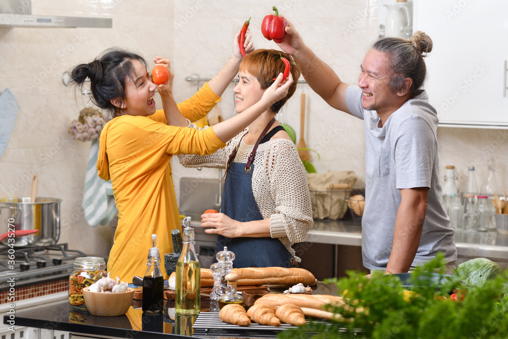 幸福的家庭，母亲、父亲和女儿在厨房做饭，一起做健康的食物，感觉很好