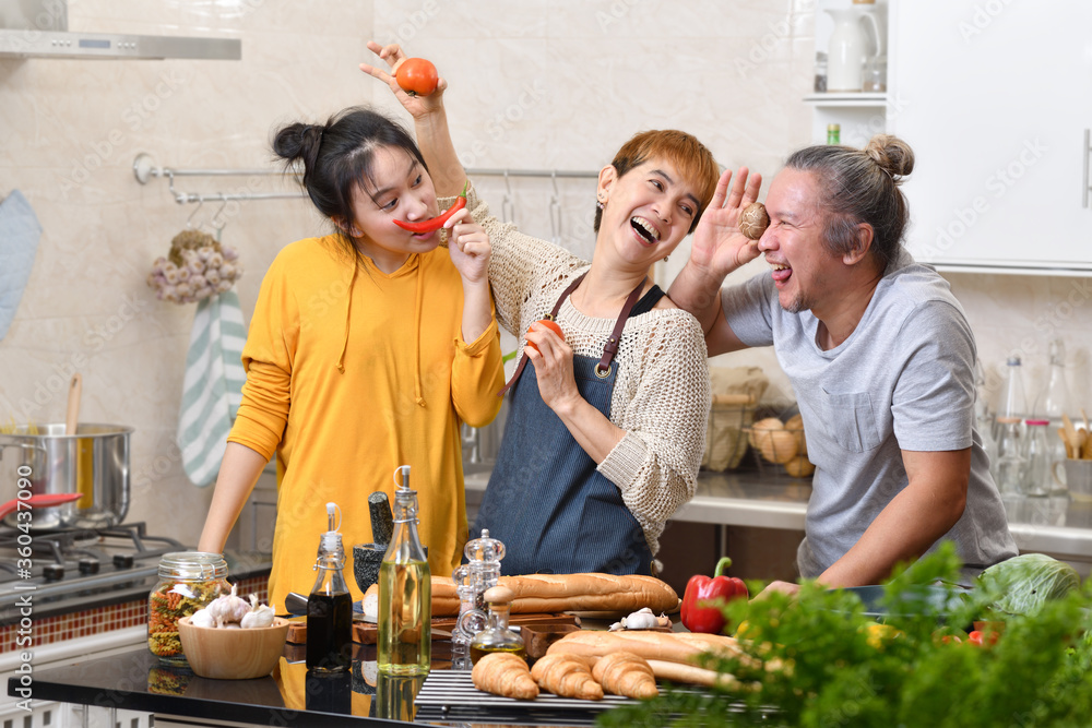 幸福的家庭，母亲、父亲和女儿在厨房做饭，一起做健康的食物，感觉很好