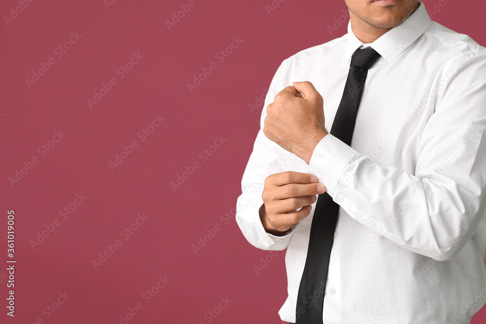 Young businessman in stylish shirt on color background