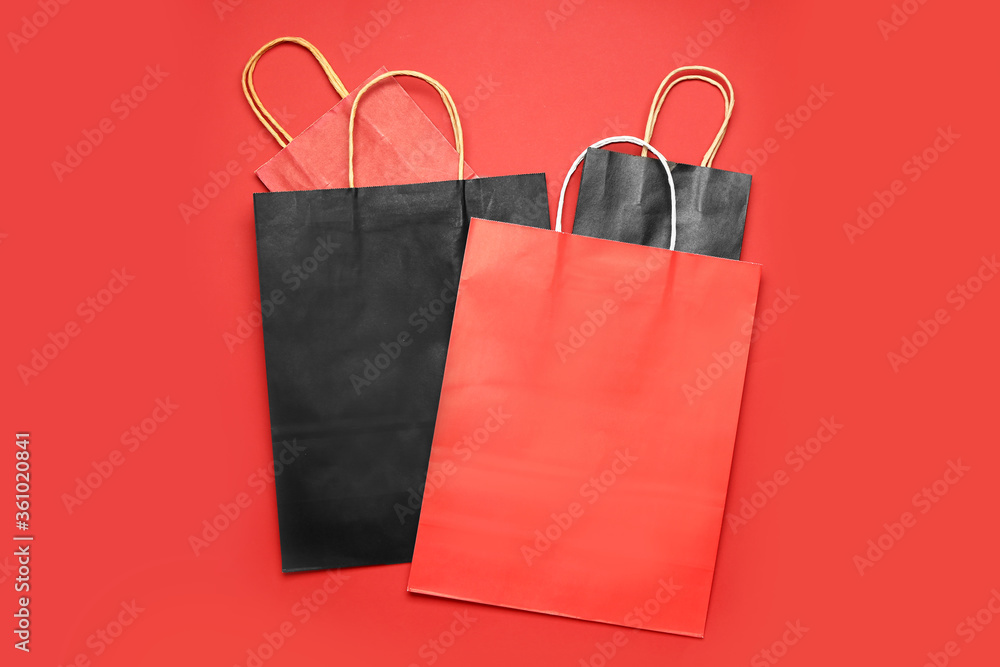 Paper shopping bags on color background