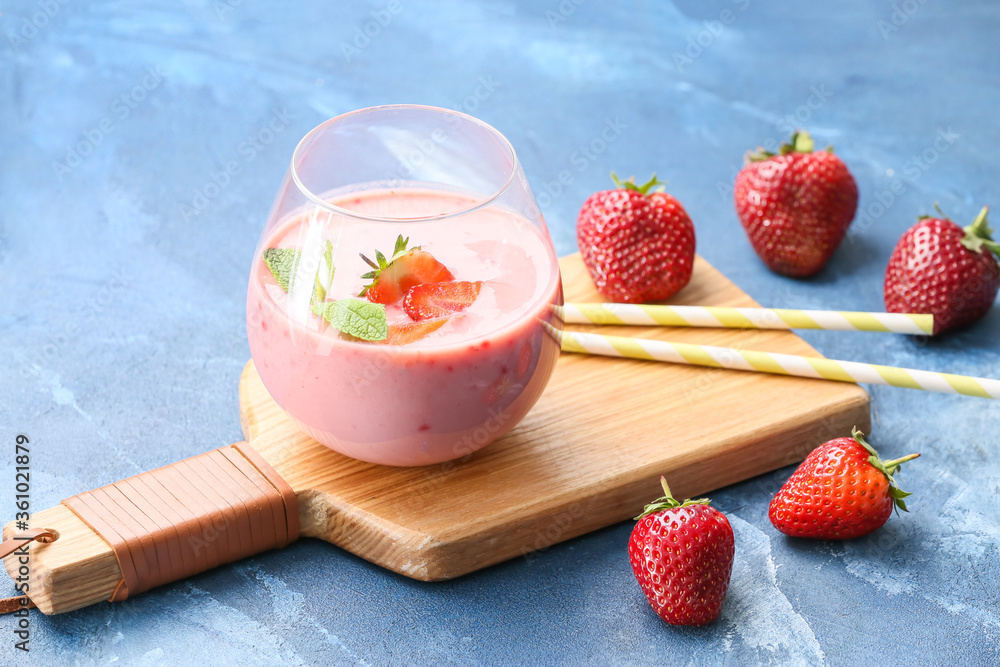 Glass of tasty strawberry smoothie on color background