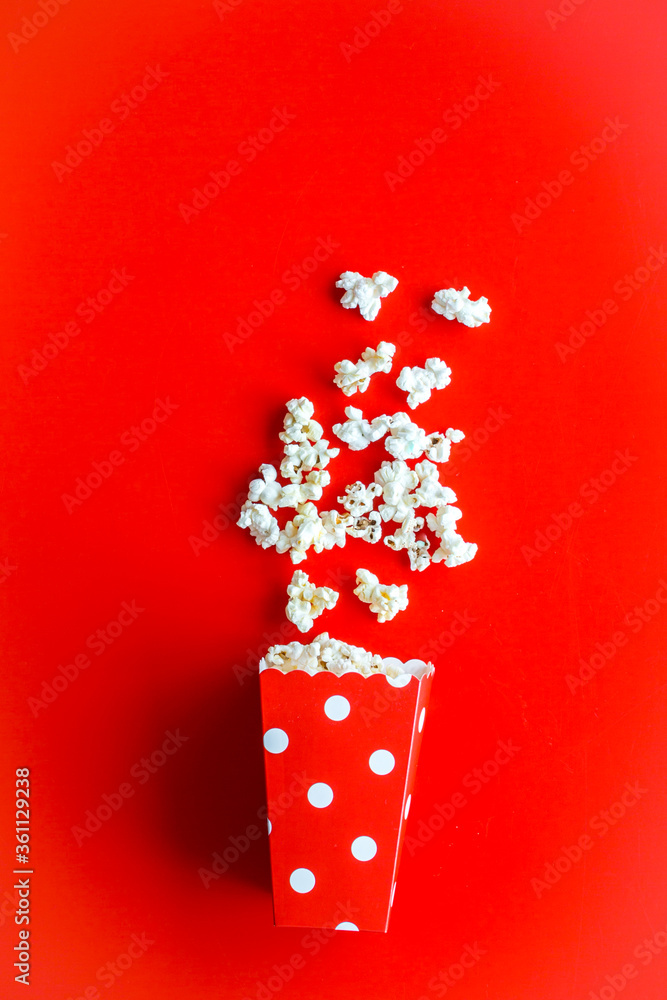 Popcorn in paper cup on red desk top view