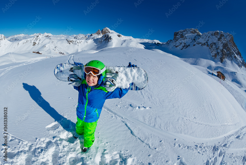 Wide mountain panorama and cute little smiling boy hold snowboard on shoulders view from above with 