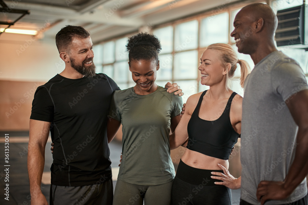 Diverse friends laughing after a workout together at the gym