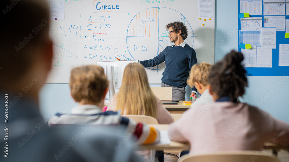 Caring Teacher Explains Lesson to a Classroom Full of Bright Diverse Children. In Elementary School 