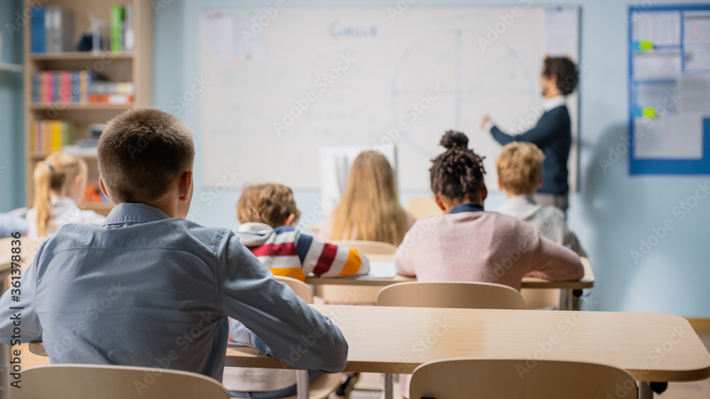 Talented Teacher Explains Lesson to a Classroom Full of Bright Diverse Children. In Elementary Schoo