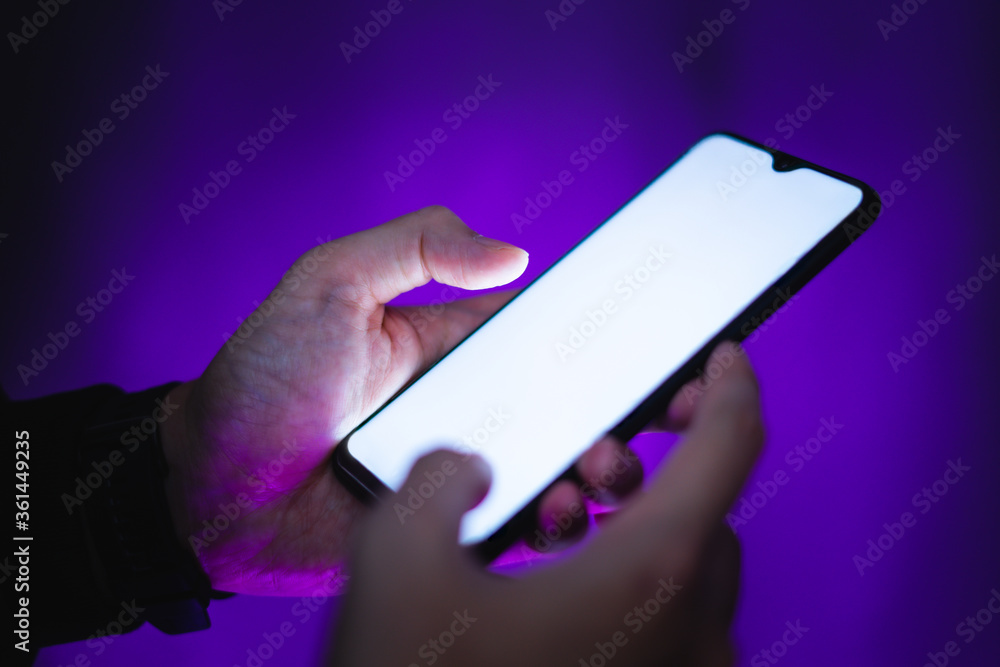 hand holds smartphone in the nightclub