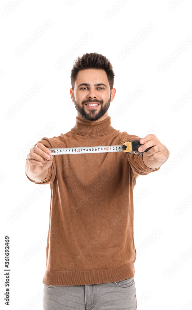 Young man with measuring tape on white background