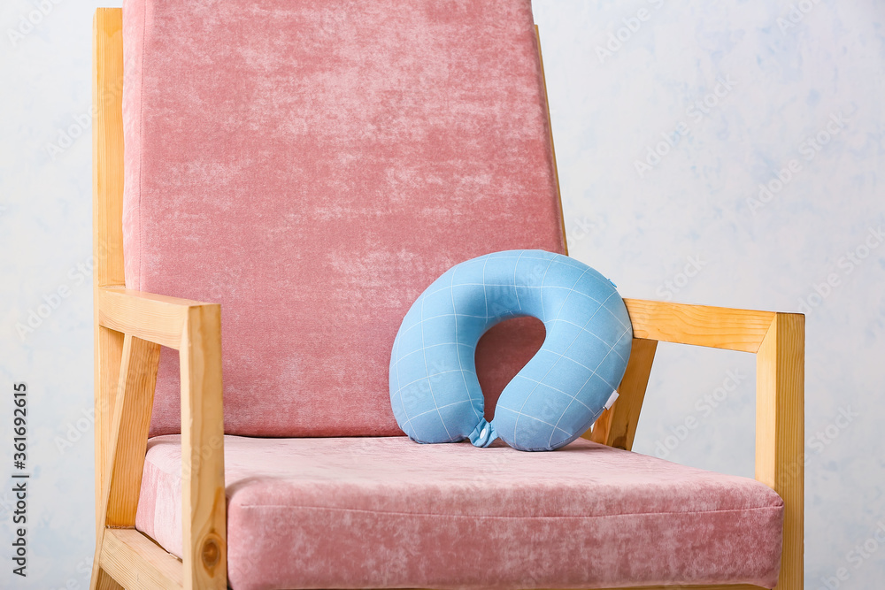 Travel pillow in armchair at home