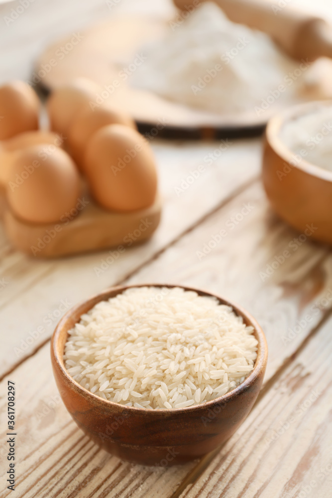 Bowl with raw rice on table